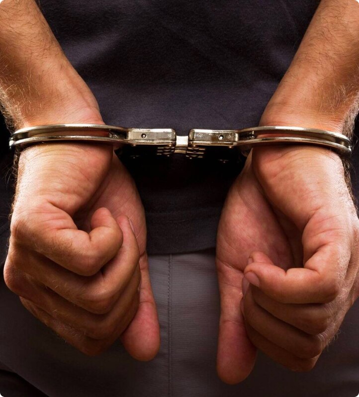 close up of criminals hands in handcuffs